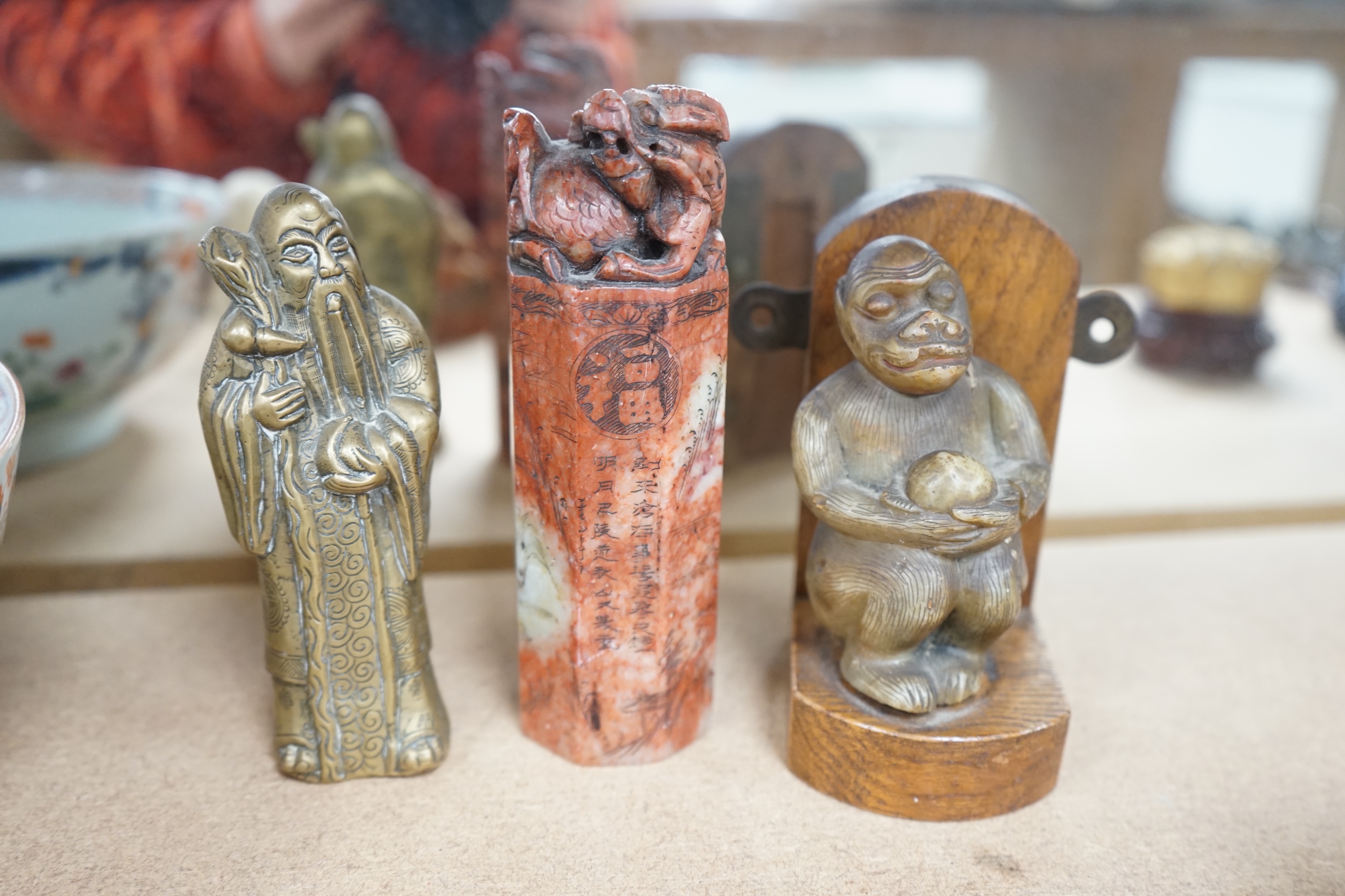 Five Chinese soapstone seals, a bronze figure of a Shou Lao, a pottery dog, a carved soapstone monkey and a Chinese famille rose bowl, 18th century, tallest 15cm high. Condition - poor to good